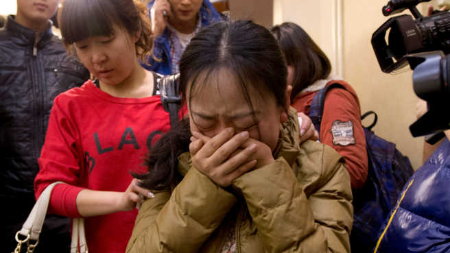 A Chinese relative of passengers aboard in a missing Malaysia Airlines plane, center, cries as she is escorted by a woman while leaving a hotel room for relatives or friends of passengers aboard the missing airplane, in Beijing. Photo - AP A Chinese relative of passengers aboard in a missing Malaysia Airlines plane, center, cries as she is escorted by a woman while leaving a hotel room for relatives or friends of passengers aboard the missing airplane, in Beijing. Photo - AP